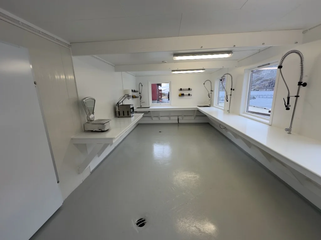 The fish filleting room at Myrfjord, with work surfaces and washing facilities.